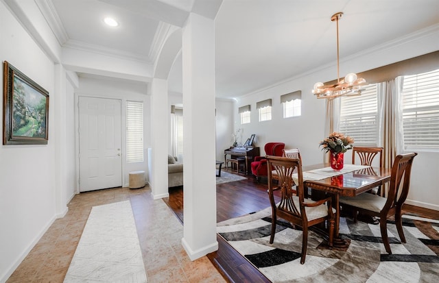 dining room featuring an inviting chandelier, arched walkways, baseboards, and ornamental molding