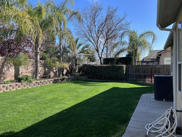 view of yard with a fenced backyard and central AC