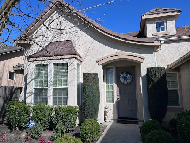 entrance to property featuring stucco siding