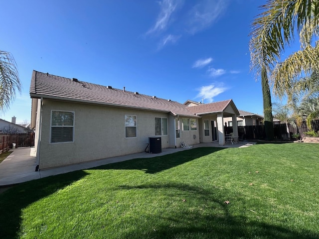 rear view of house with a patio, a yard, and fence