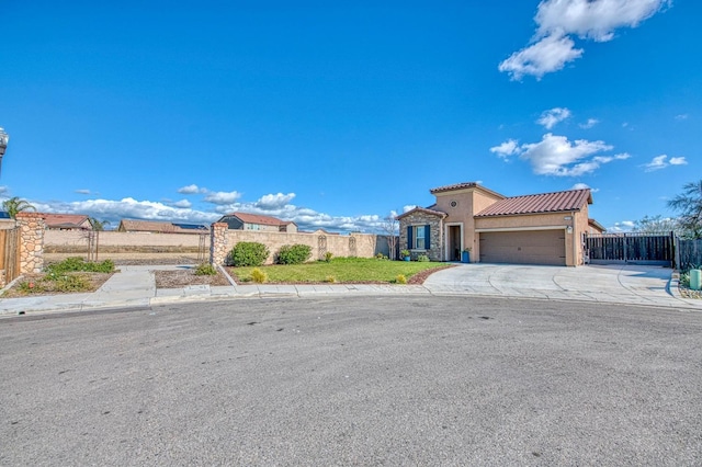 mediterranean / spanish-style home with a garage, concrete driveway, a tile roof, fence, and stucco siding