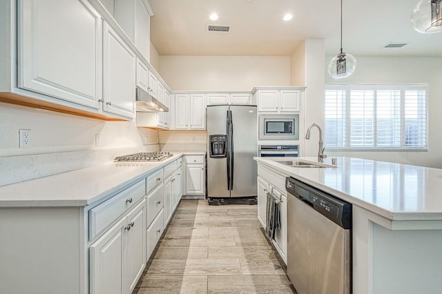 kitchen featuring stainless steel appliances, light countertops, visible vents, white cabinets, and a sink