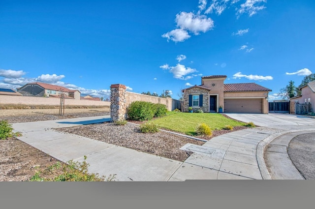 mediterranean / spanish home with stucco siding, concrete driveway, an attached garage, fence, and stone siding