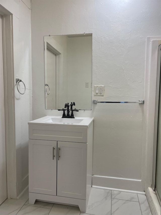 bathroom with marble finish floor and vanity