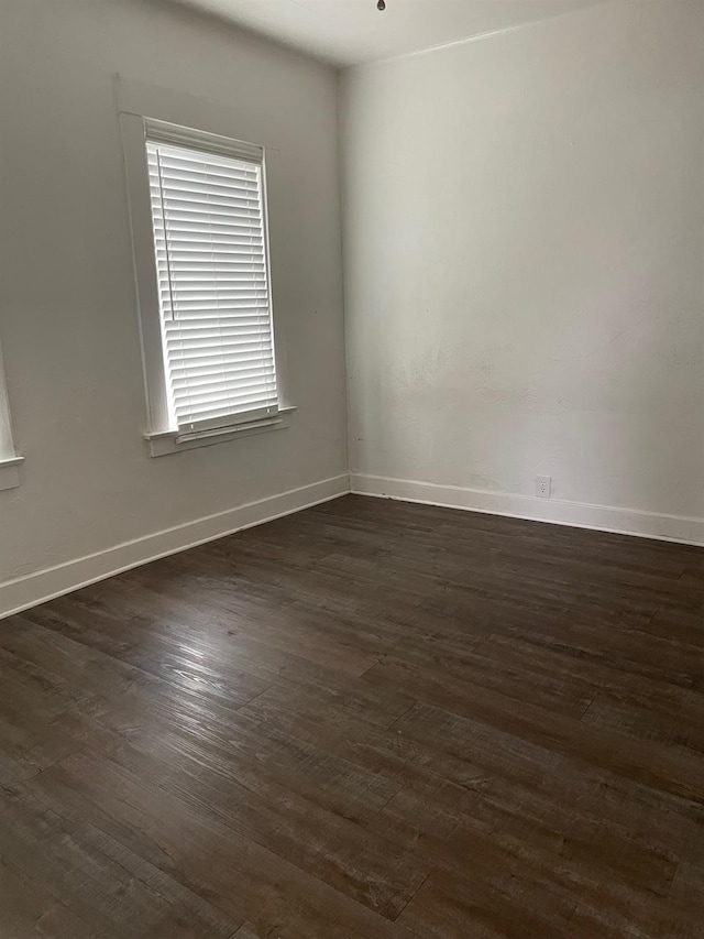 spare room with dark wood-style floors and baseboards