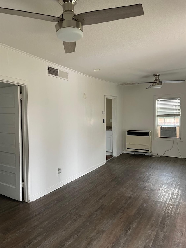 unfurnished living room with visible vents, a ceiling fan, dark wood-style flooring, heating unit, and cooling unit