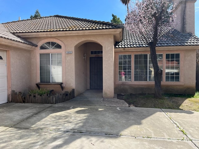 property entrance with an attached garage and stucco siding