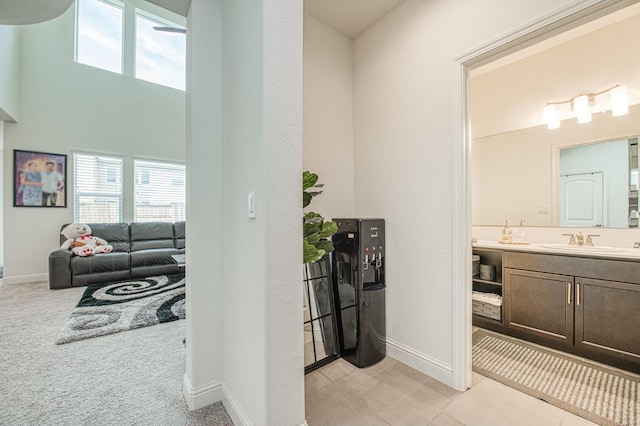 bathroom with a high ceiling, baseboards, and vanity