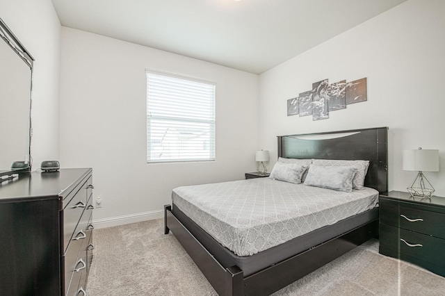 bedroom featuring light carpet and baseboards