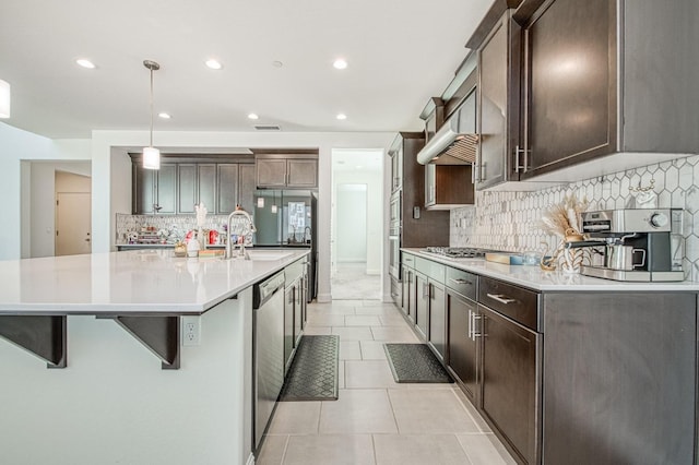 kitchen with light tile patterned floors, stainless steel appliances, a spacious island, visible vents, and dark brown cabinets