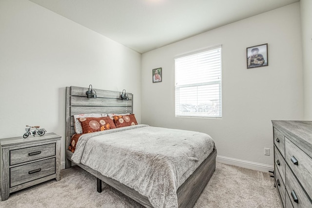 bedroom featuring baseboards and light colored carpet