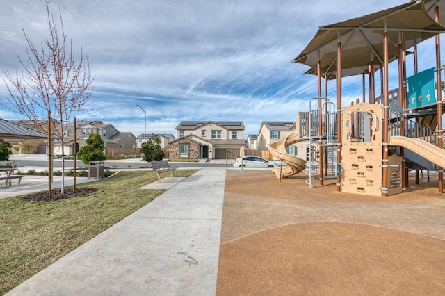 communal playground featuring a residential view and a yard