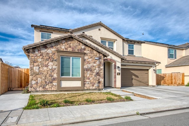 mediterranean / spanish-style house with a tile roof, fence, driveway, and stucco siding