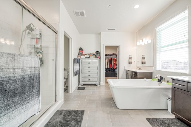 full bath with a stall shower, vanity, visible vents, and tile patterned floors