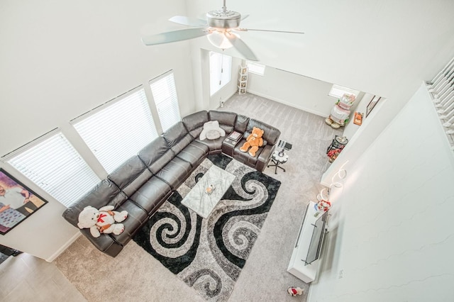 carpeted living room featuring ceiling fan and baseboards