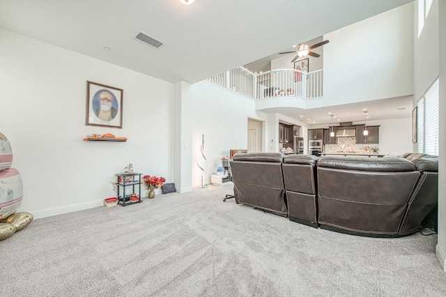 living room featuring baseboards, visible vents, ceiling fan, and carpet flooring