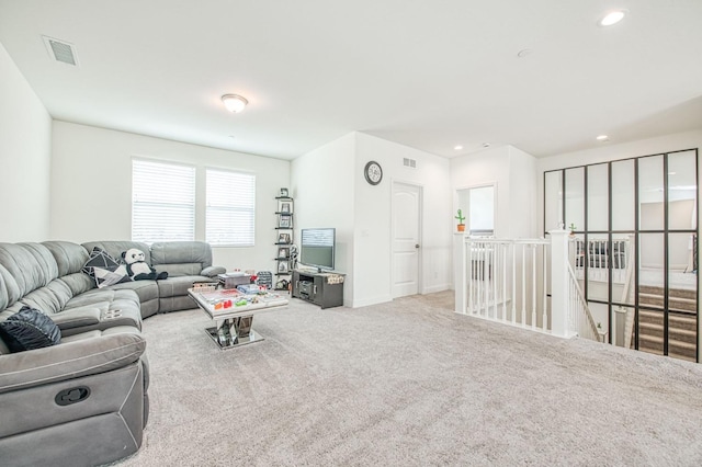 carpeted living room featuring baseboards, visible vents, and recessed lighting