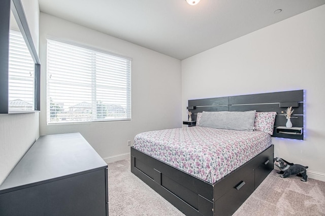 bedroom featuring light colored carpet and baseboards