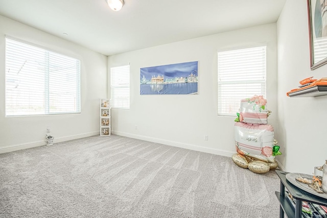 carpeted spare room featuring baseboards