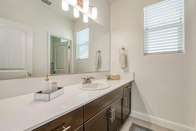 bathroom with visible vents, tile patterned flooring, vanity, and baseboards