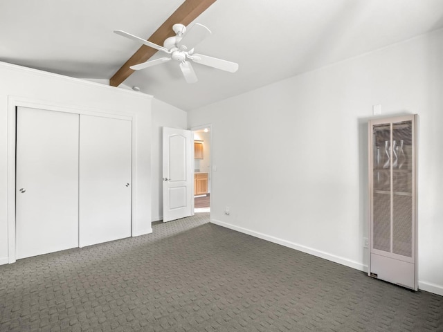 unfurnished bedroom with vaulted ceiling with beams, a heating unit, dark carpet, and baseboards