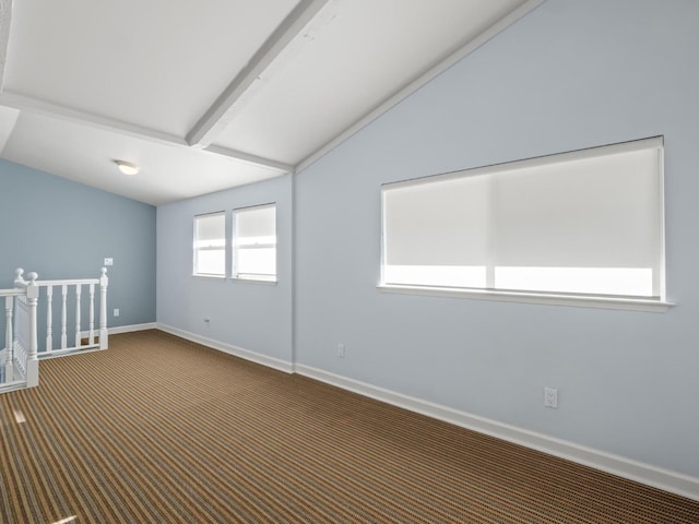 carpeted spare room with lofted ceiling with beams and baseboards