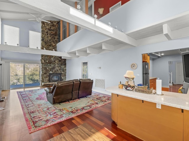 living area with high vaulted ceiling, beamed ceiling, wood finished floors, and visible vents