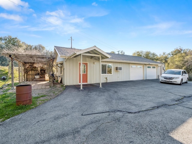 single story home with driveway, board and batten siding, and roof with shingles