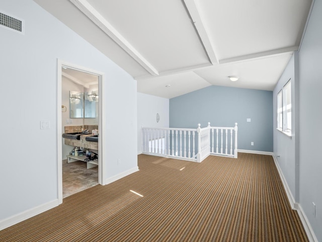 carpeted empty room with lofted ceiling, visible vents, and baseboards