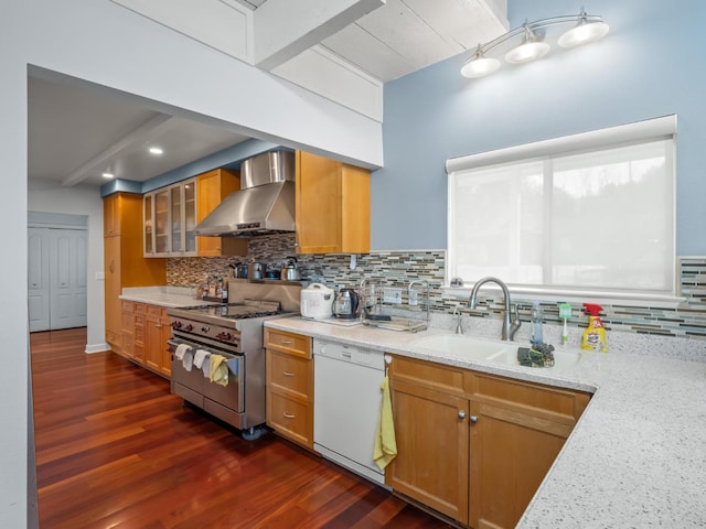 kitchen featuring dark wood finished floors, high end stainless steel range, a sink, dishwasher, and wall chimney exhaust hood