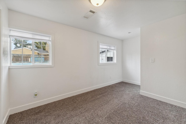 carpeted empty room with baseboards and visible vents