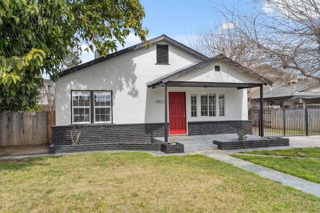 bungalow with fence, a front lawn, and stucco siding