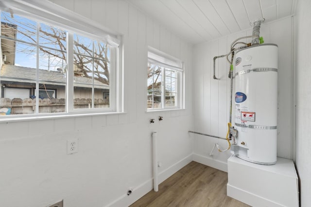 clothes washing area with laundry area, wood ceiling, strapped water heater, wood finished floors, and hookup for an electric dryer