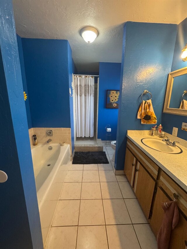 full bath with a textured ceiling, tile patterned flooring, toilet, vanity, and a bath