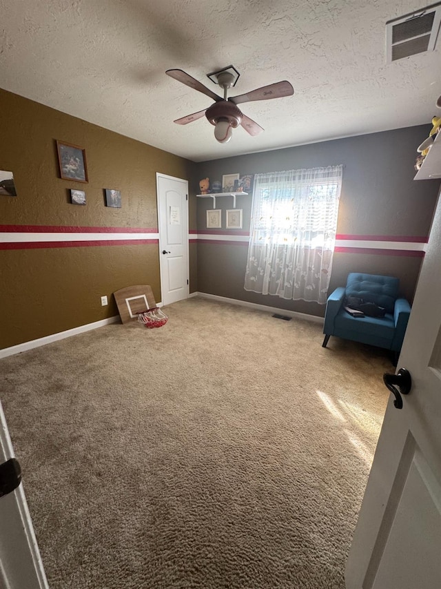 interior space with a textured ceiling, visible vents, carpet flooring, and a textured wall