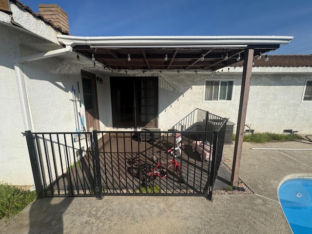 property entrance featuring a patio and stucco siding