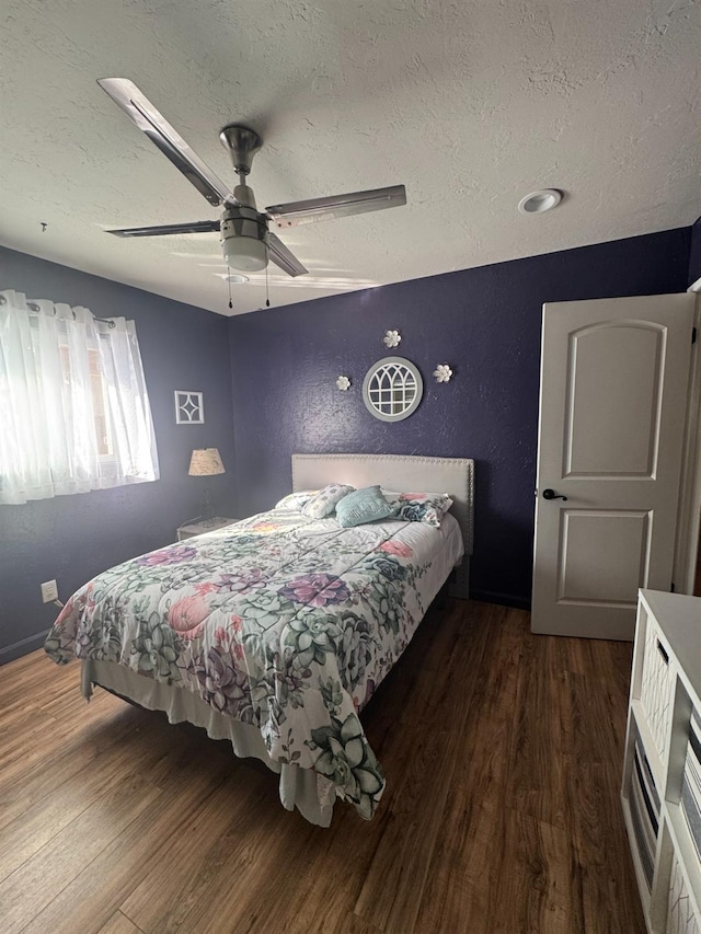 bedroom with dark wood-style floors, ceiling fan, and a textured ceiling