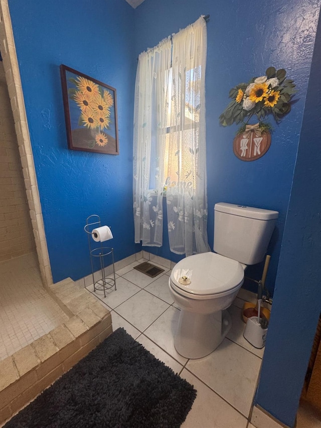 full bathroom featuring visible vents, tile patterned flooring, toilet, and a shower stall