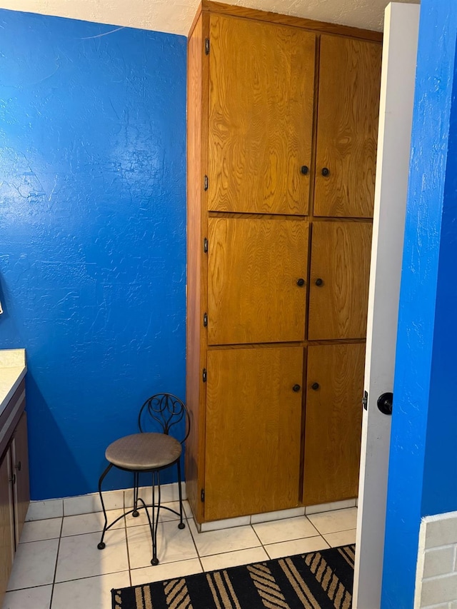 bathroom featuring tile patterned flooring, vanity, and baseboards