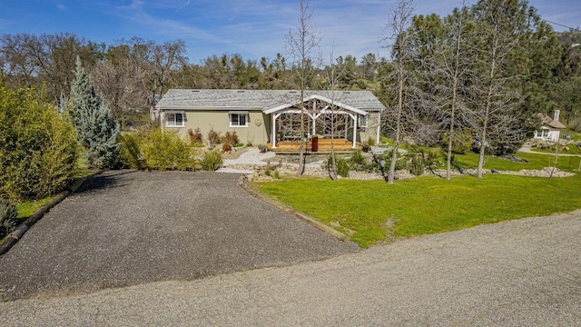 view of front of house featuring gravel driveway and a front lawn