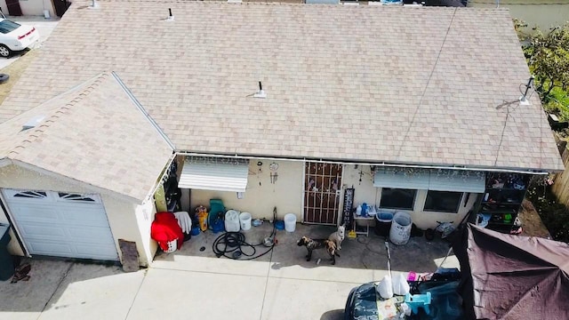 exterior space with a garage and a shingled roof