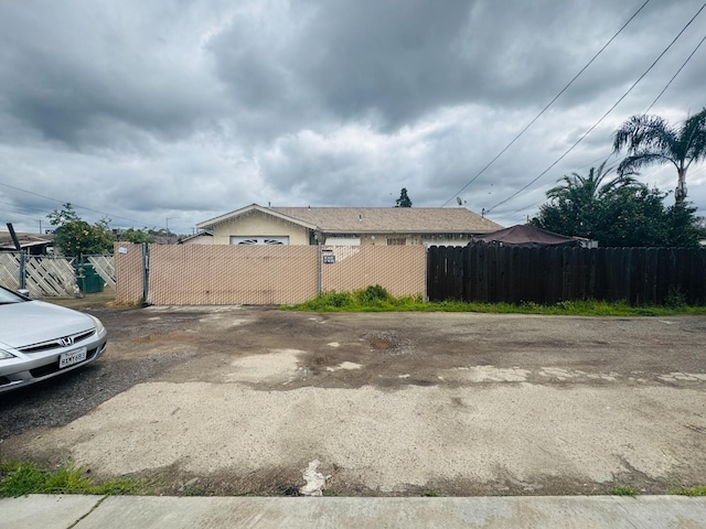 view of side of home featuring a fenced front yard and a gate