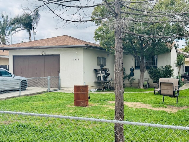 exterior space with fence, a lawn, and stucco siding