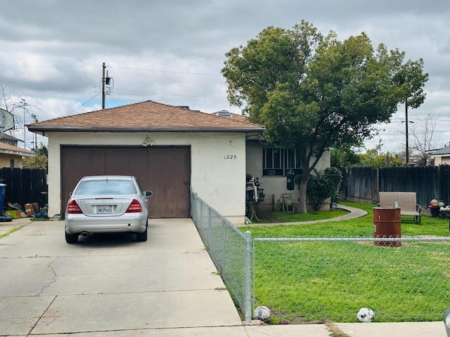 ranch-style home with stucco siding, concrete driveway, an attached garage, fence private yard, and a front lawn