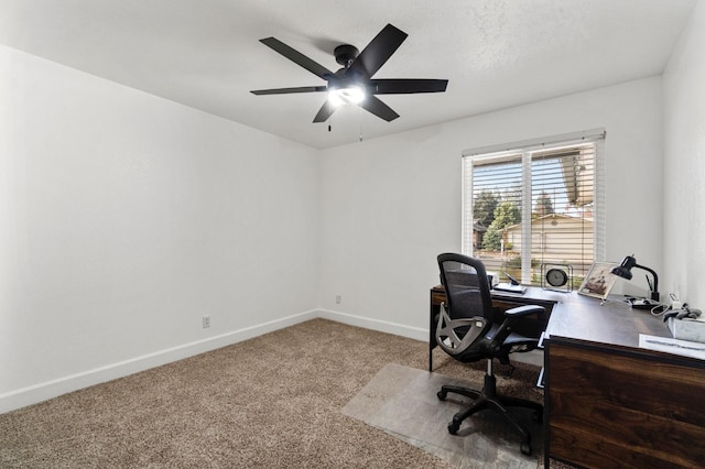 carpeted home office featuring a ceiling fan and baseboards