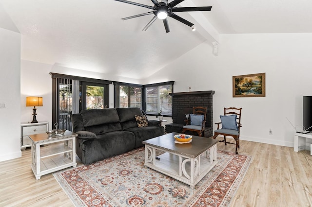 living room with lofted ceiling with beams, light wood-style floors, a brick fireplace, and baseboards