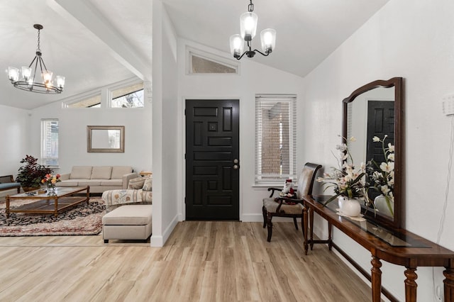 entryway featuring light wood-type flooring, an inviting chandelier, and vaulted ceiling