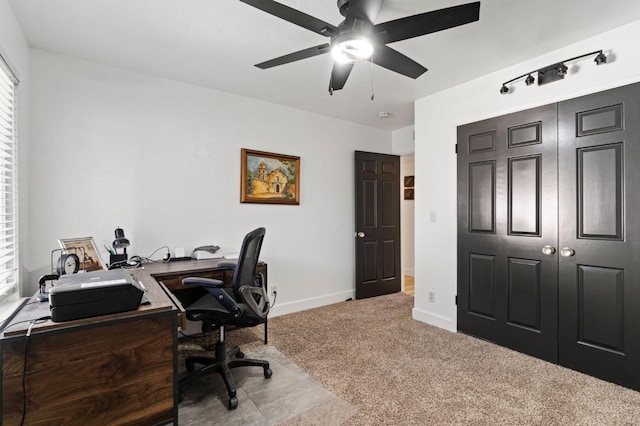 carpeted office featuring ceiling fan and baseboards