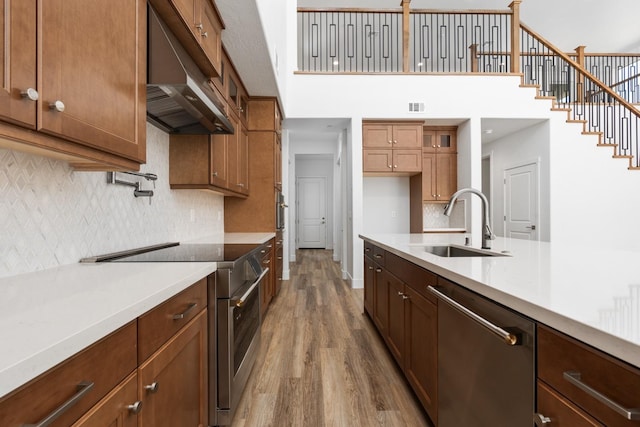 kitchen featuring light countertops, visible vents, appliances with stainless steel finishes, a sink, and under cabinet range hood