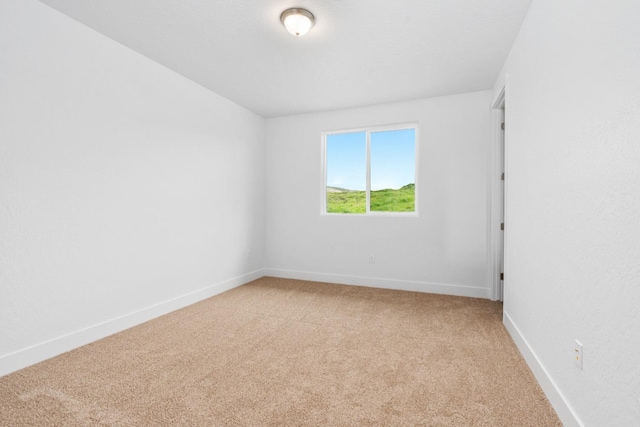 unfurnished room featuring light colored carpet and baseboards